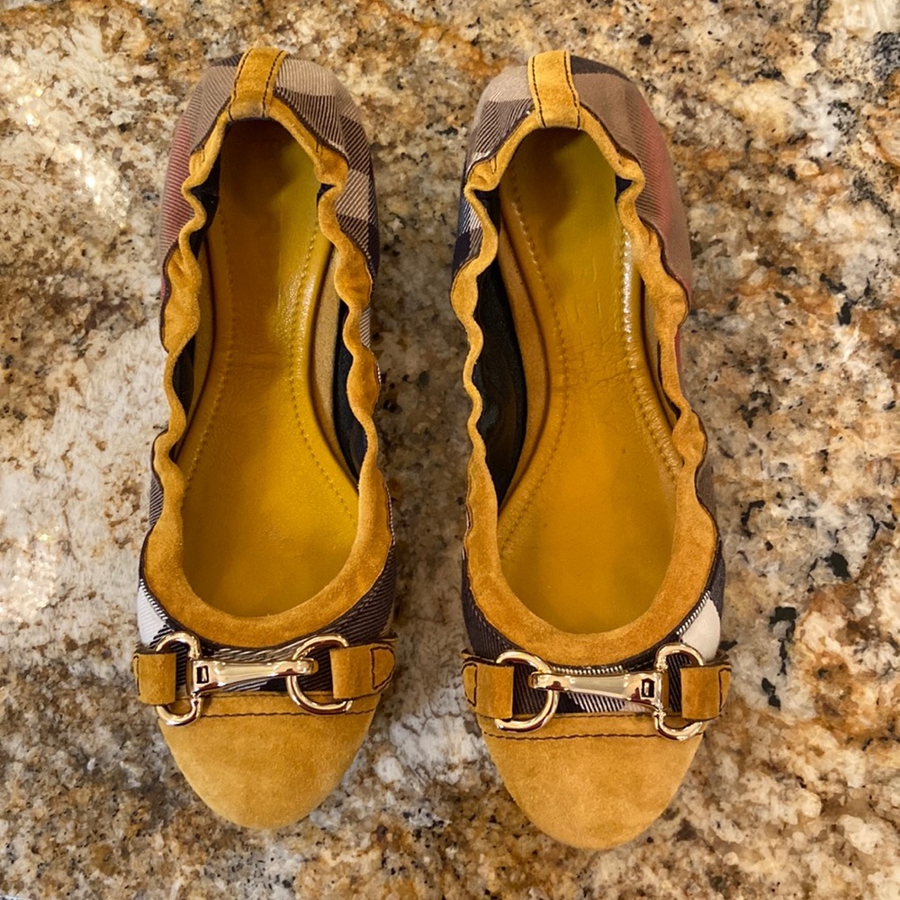 Burberry brand Shipley ballet flats with gold buckle hardware.